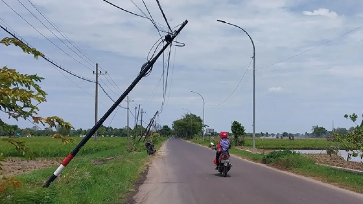 Salah satu tiang internet di ruas jalan Merakurak dan Jenu yang miring dan hampir roboh ke jalan. (RADAR TUBAN)